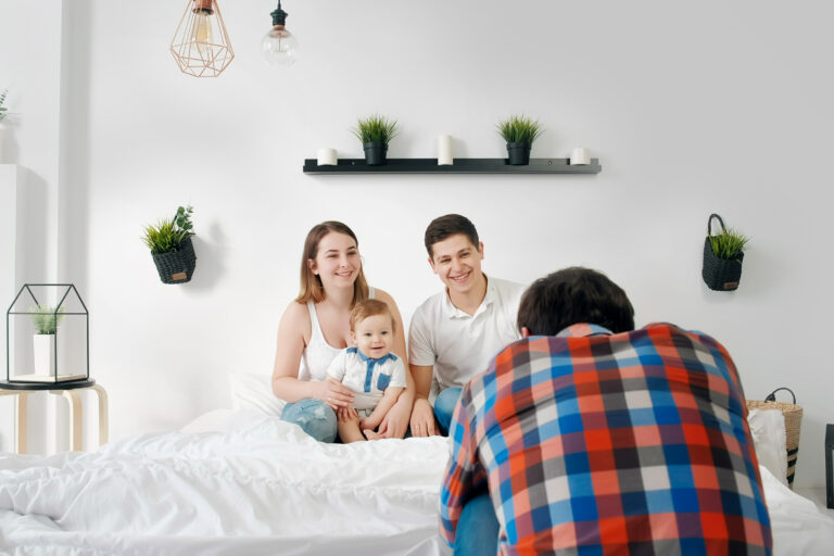 Fotograf wykonujący rodzinne zdjęcie rodziców z dzieckiem w domu