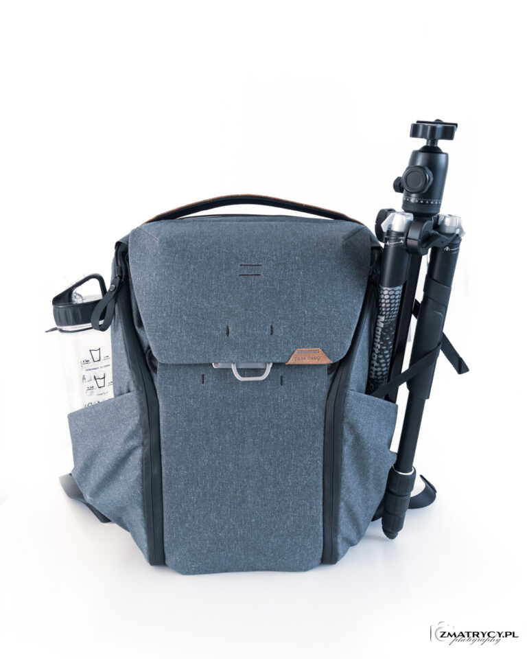 Everyday Backpack z przezroczystą butelką w jednej kieszeni i statywem w drugiej