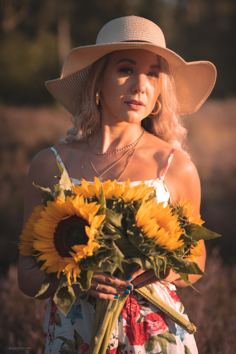 kobieta w sukience i bukietem słoneczników o zachodzie słońca