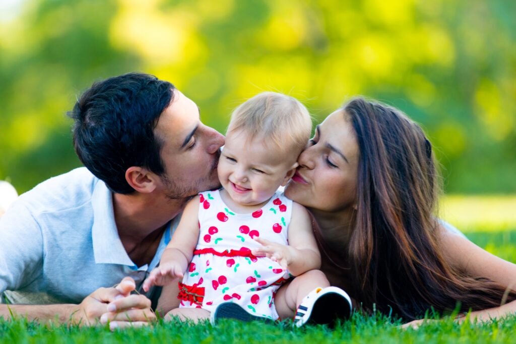 para rodziców całująca w policzek radosne dziecko