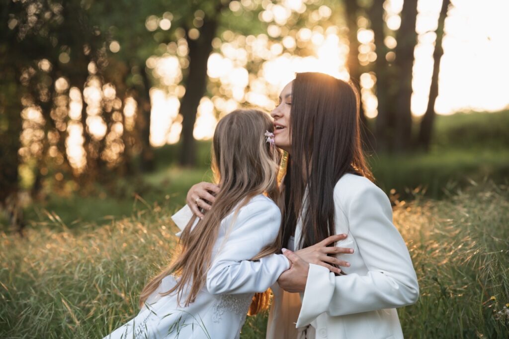 Mother and daughter embracing in the woods