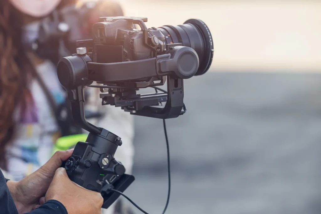 Aparat z obiektywem filmowym na gimbalu trzymanym przez operatora