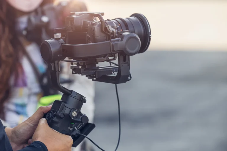Aparat z obiektywem filmowym na gimbalu trzymanym przez operatora