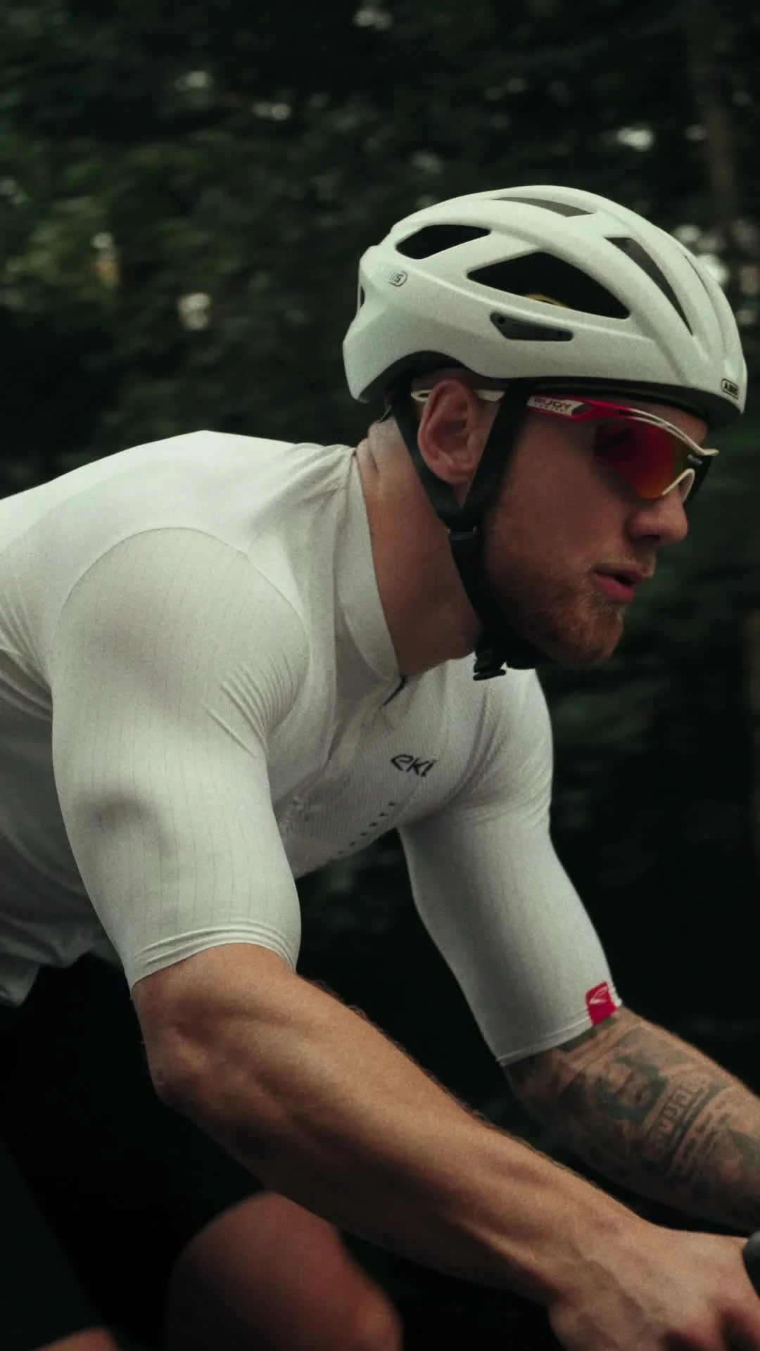 Road cyclist wearing a white helmet and glasses