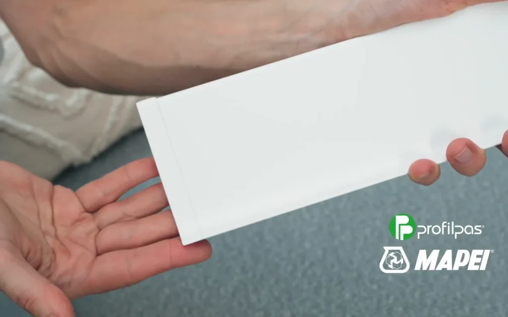 White Metal Line 90 strip held in hands, a frame from the product film for @durkaarch's collaboration with MAPEI