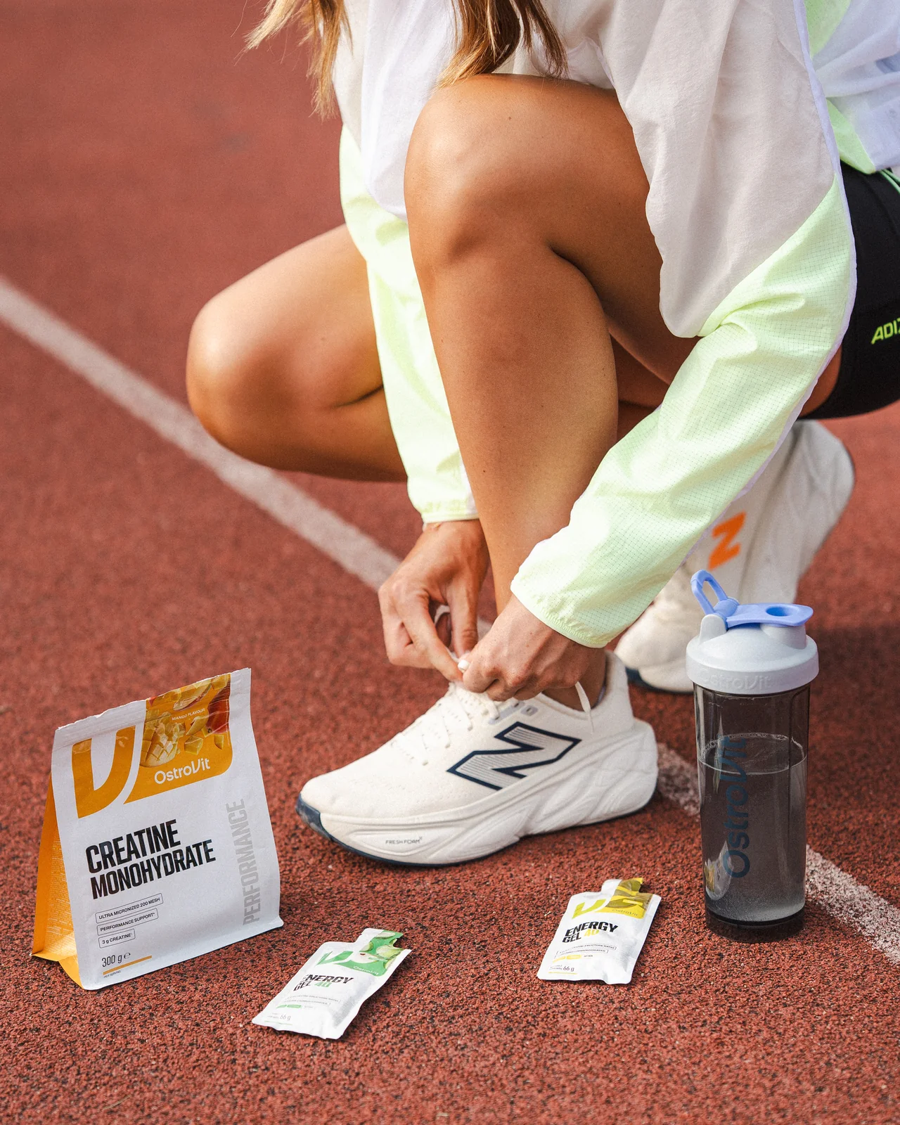 But sportowy, shaker i produkty OstroVit na czerwonej bieżni.